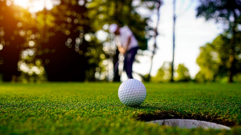 Albright Land & Development at Cedar Creek Lake | Golf ball rolls near the cup with golfer blurred in the background.