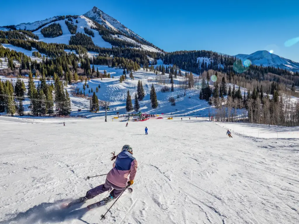 Albright Land & Development at Cedar Creek Lake | Skier speeds down Crested Butte Mountain in Colorado with mountain peak in the background.
